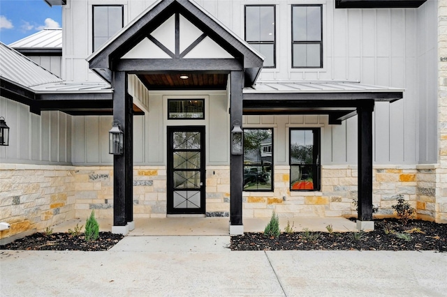 doorway to property with board and batten siding and a standing seam roof