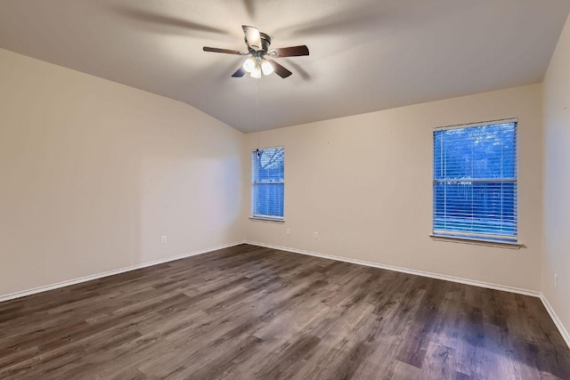 empty room featuring dark wood-style floors, vaulted ceiling, baseboards, and ceiling fan