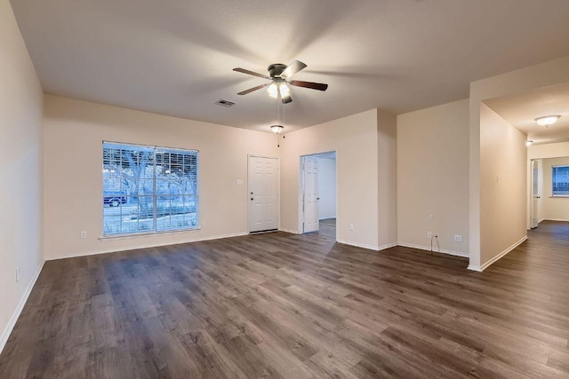 unfurnished living room featuring dark wood-style floors, baseboards, visible vents, and a ceiling fan