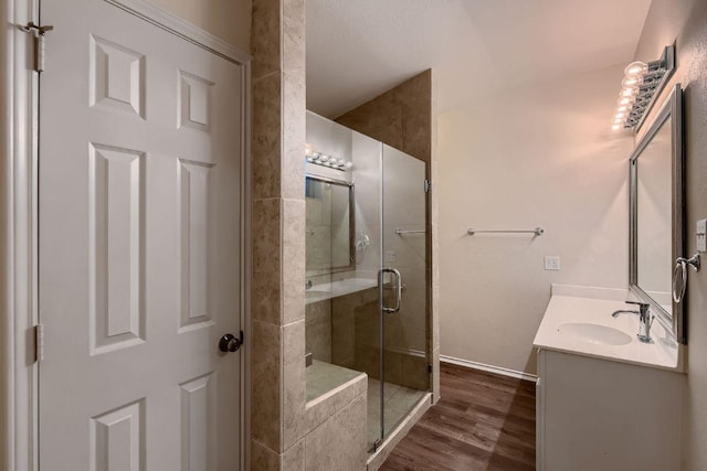 bathroom with a stall shower, wood finished floors, and vanity