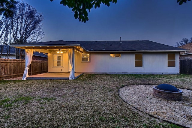 rear view of property with ceiling fan, a patio, an outdoor fire pit, a shingled roof, and fence