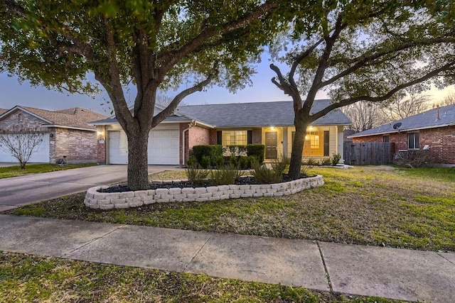 ranch-style house featuring a garage, concrete driveway, brick siding, and fence