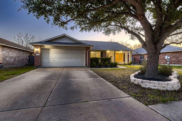 ranch-style home with a garage, concrete driveway, and brick siding