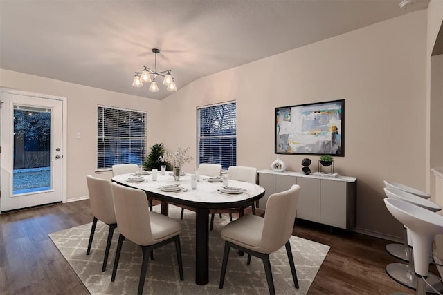 dining space with vaulted ceiling, dark wood-style flooring, baseboards, and an inviting chandelier