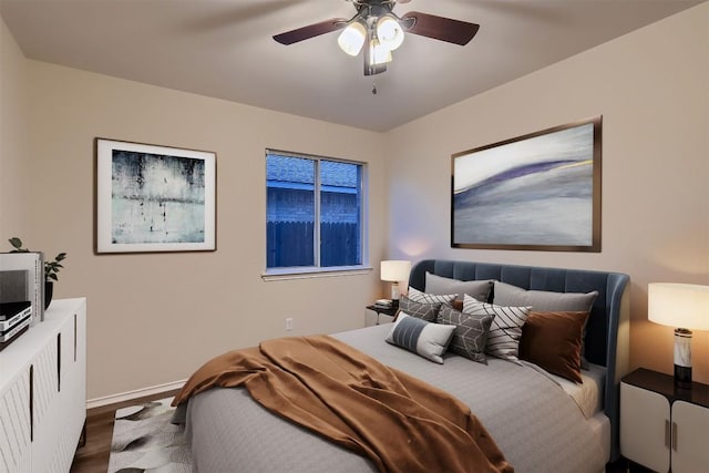 bedroom featuring ceiling fan, wood finished floors, and baseboards