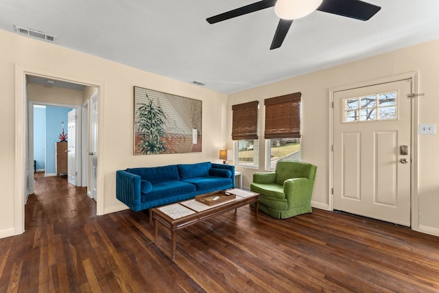 living area featuring visible vents, ceiling fan, baseboards, and hardwood / wood-style flooring