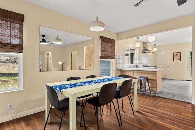 dining space with baseboards and wood finished floors