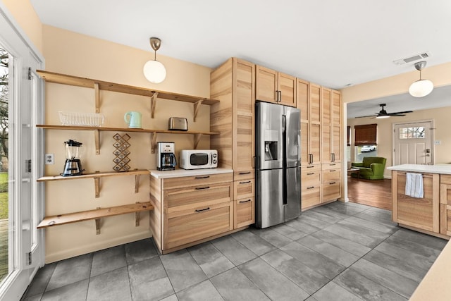 kitchen with stainless steel fridge, visible vents, white microwave, light brown cabinets, and open shelves