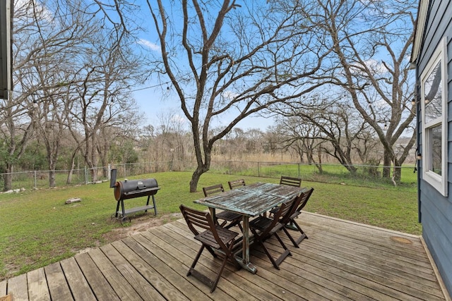 wooden terrace featuring a yard, outdoor dining space, area for grilling, and a fenced backyard