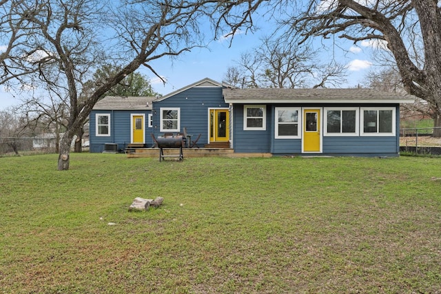 view of front of home featuring a shingled roof, fence, and a front yard