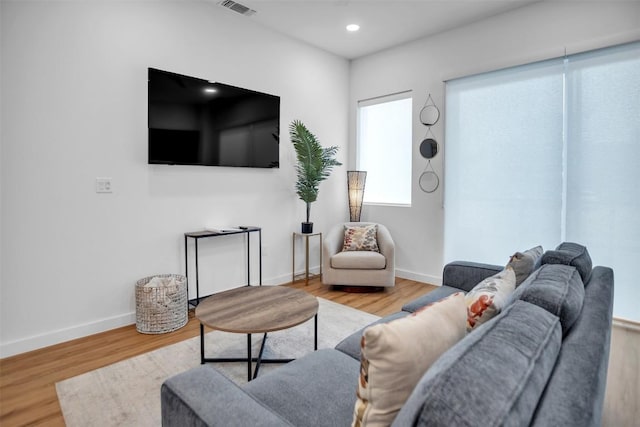 living room featuring recessed lighting, visible vents, baseboards, and wood finished floors