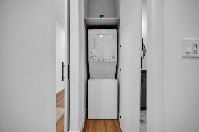 washroom featuring a sink, stacked washer and dryer, laundry area, and light wood-style floors