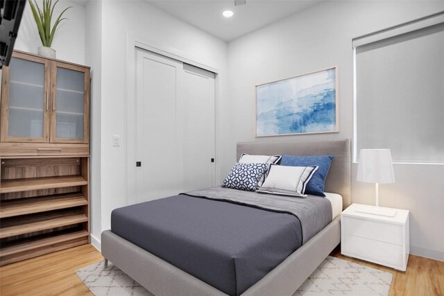 bedroom with a closet, wood finished floors, and recessed lighting