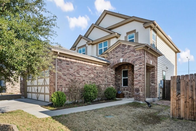 view of front of home featuring stucco siding, fence, concrete driveway, and brick siding