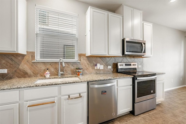 2950 E Old Settlers Blvd Unit 55, Round Rock, TX 78665 - kitchen featuring appliances with stainless steel finishes, white cabinets, backsplash, light stone countertops, and plenty of natural light