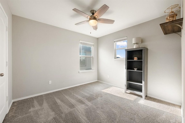 unfurnished bedroom with carpet flooring, a ceiling fan, and baseboards