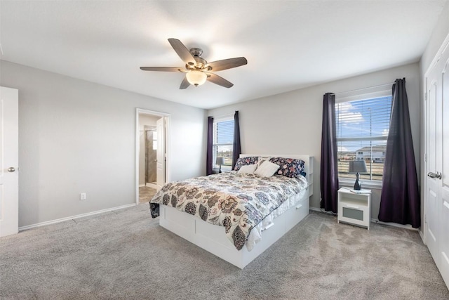 bedroom with light carpet, ceiling fan, multiple windows, and baseboards