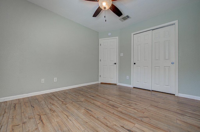 unfurnished bedroom with baseboards, a closet, visible vents, and light wood-style floors