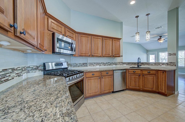 kitchen featuring visible vents, brown cabinetry, appliances with stainless steel finishes, decorative light fixtures, and a sink