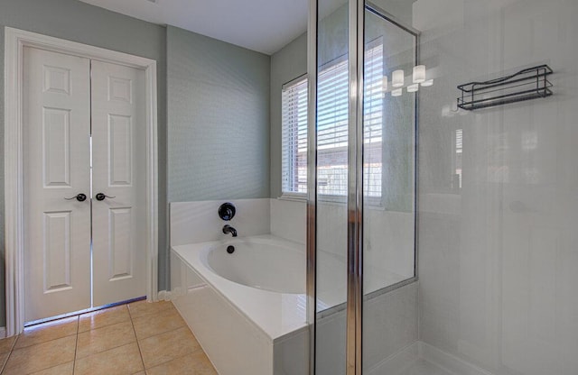 bathroom with a garden tub, a shower stall, and tile patterned floors