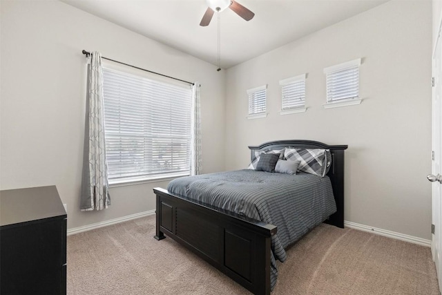 bedroom with light carpet, ceiling fan, and baseboards