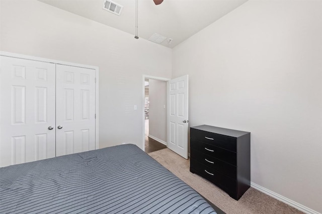 bedroom with a closet, visible vents, light carpet, and baseboards