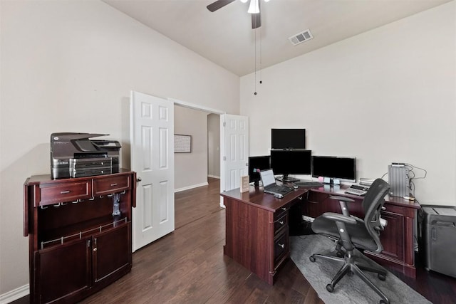 office space featuring ceiling fan, dark wood-style flooring, visible vents, baseboards, and vaulted ceiling