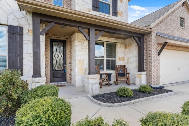 view of exterior entry with a porch, stone siding, roof with shingles, and an attached garage