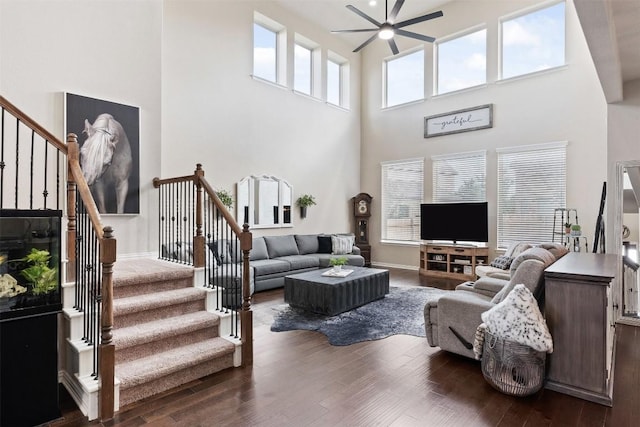 living area with a ceiling fan, dark wood-style flooring, stairway, and baseboards