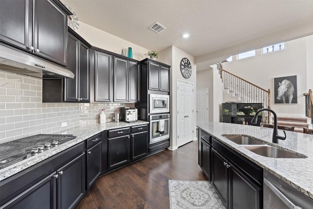 kitchen featuring light stone countertops, appliances with stainless steel finishes, and a sink