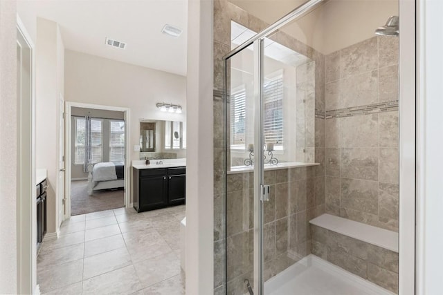 ensuite bathroom featuring tile patterned flooring, connected bathroom, vanity, visible vents, and a stall shower