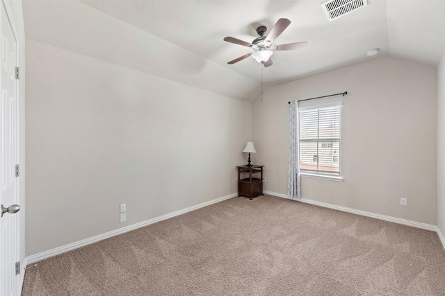 empty room featuring vaulted ceiling, carpet, visible vents, and a ceiling fan