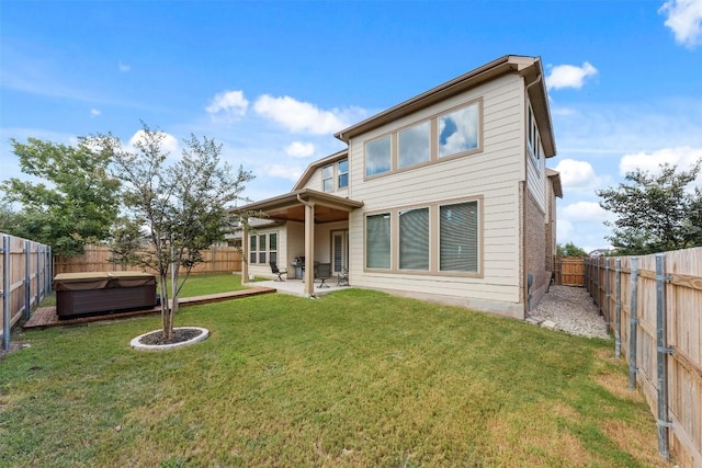 back of property featuring a fenced backyard, a patio, and a lawn