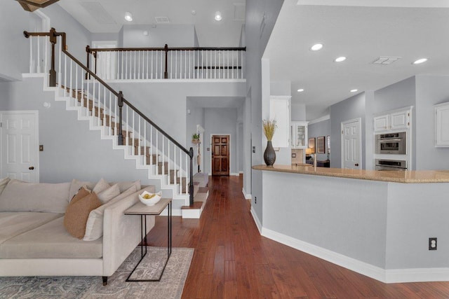 living room with recessed lighting, visible vents, baseboards, stairs, and dark wood finished floors