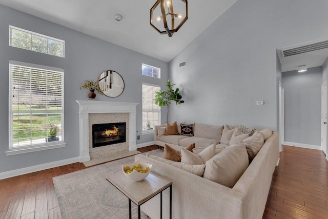 living area featuring high vaulted ceiling, plenty of natural light, visible vents, and wood-type flooring