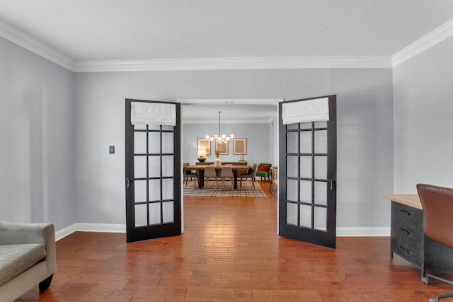 doorway to outside with french doors, hardwood / wood-style floors, ornamental molding, a chandelier, and baseboards