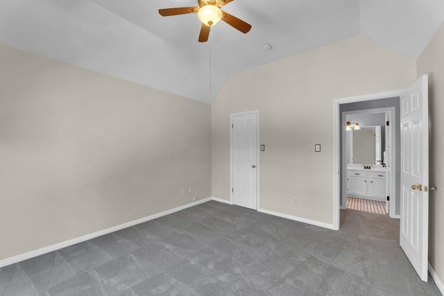 unfurnished bedroom with lofted ceiling, dark colored carpet, ceiling fan, and baseboards