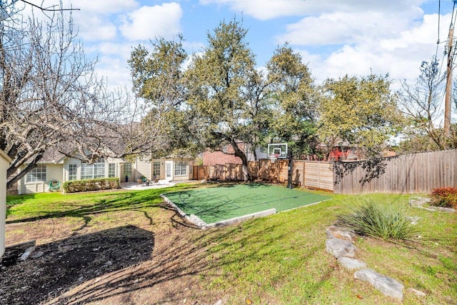 view of yard featuring fence and basketball court