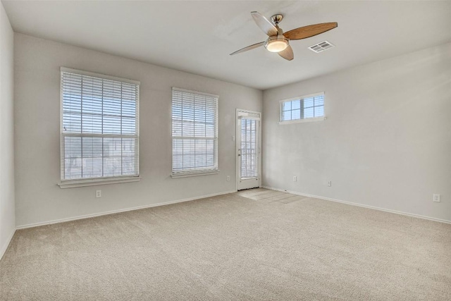 unfurnished room with ceiling fan, baseboards, visible vents, and light colored carpet