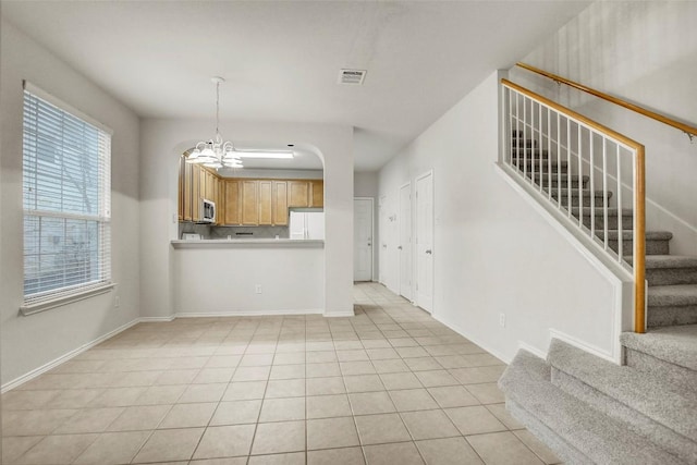 interior space with baseboards, visible vents, stairway, a notable chandelier, and light tile patterned flooring