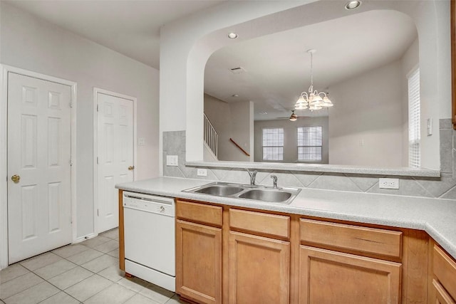 kitchen featuring light tile patterned floors, light countertops, hanging light fixtures, white dishwasher, and a sink