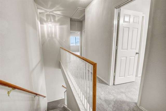 staircase with carpet floors, attic access, and baseboards