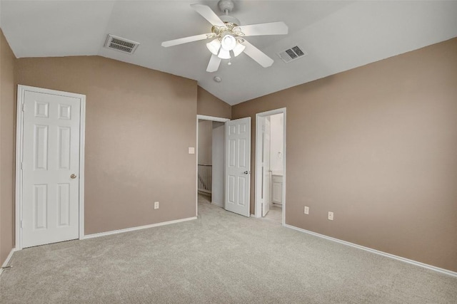 unfurnished bedroom with vaulted ceiling, visible vents, and light colored carpet