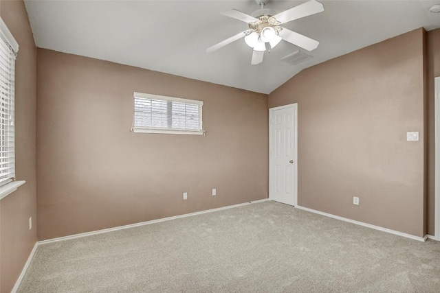 carpeted empty room featuring a ceiling fan, lofted ceiling, visible vents, and baseboards