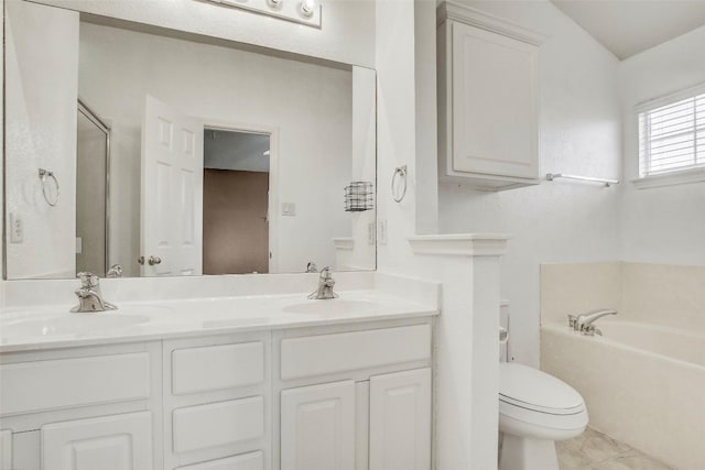 full bath featuring a garden tub, double vanity, a sink, and toilet