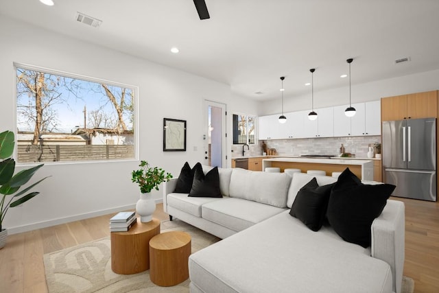 3402 Goodwin Ave Unit 1, Austin, TX 78702 - living area with healthy amount of natural light, recessed lighting, light wood finished floors, baseboards, and a ceiling fan