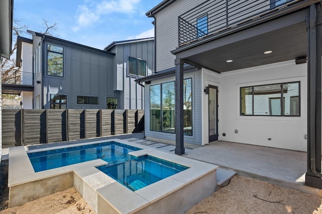 view of pool with an in ground hot tub, a patio area, and a fenced backyard