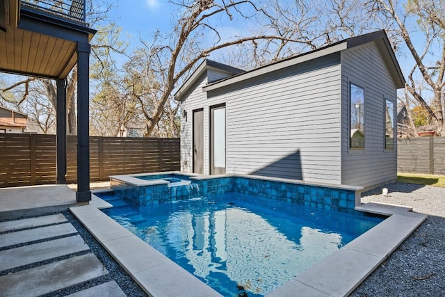 view of pool with an outbuilding, a pool with connected hot tub, and a fenced backyard