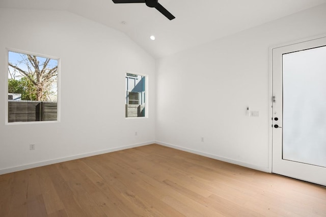 unfurnished room with a ceiling fan, baseboards, vaulted ceiling, and light wood finished floors