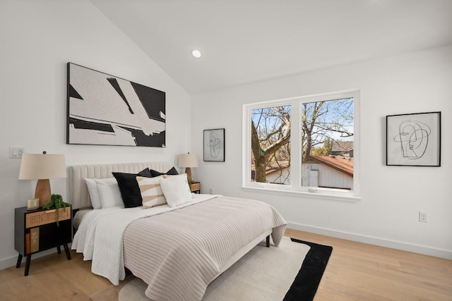 bedroom with lofted ceiling, recessed lighting, wood finished floors, and baseboards